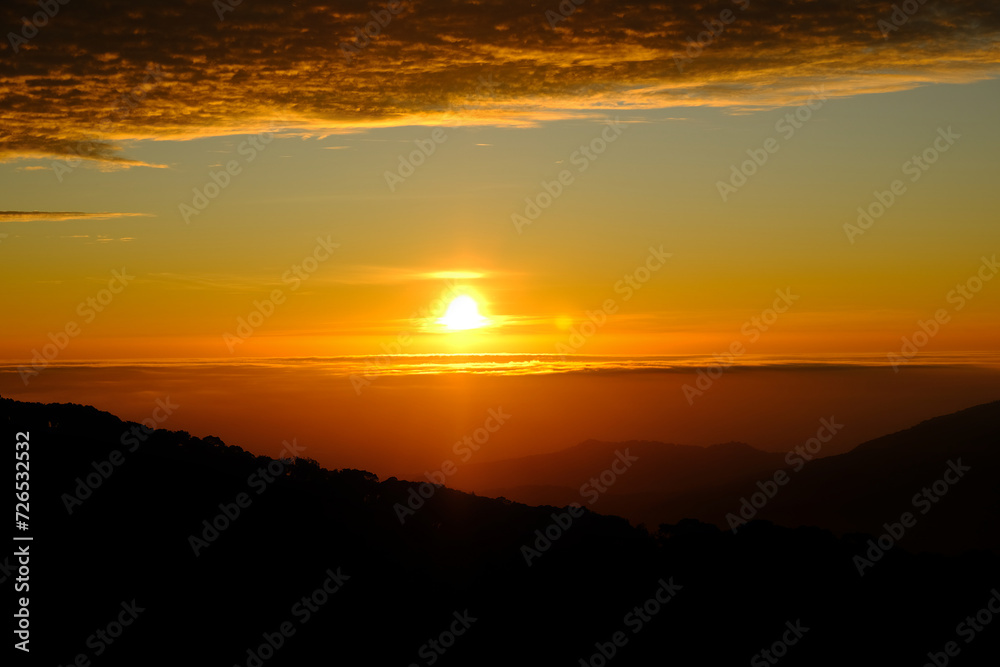 colorful dramatic sky with clouds at sunset or sunrise over the mountains 