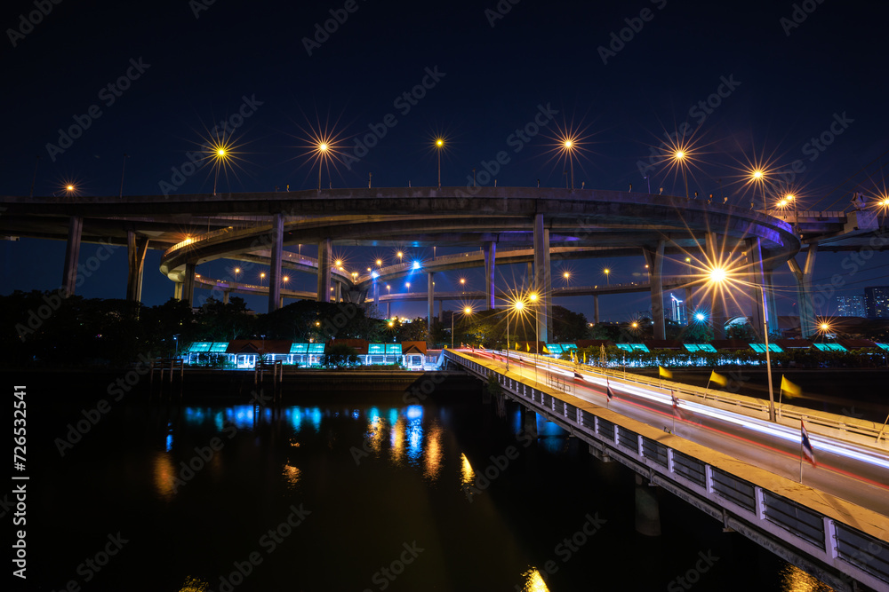 Night scene shot and over starlight effect, Bhumibol bridge and reflection of water. bangkok thailand, wide angle cityscape at night