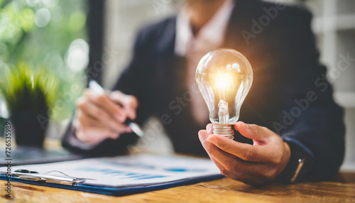 Hand holding a glowing lightbulb symbolizing creativity and business ideas