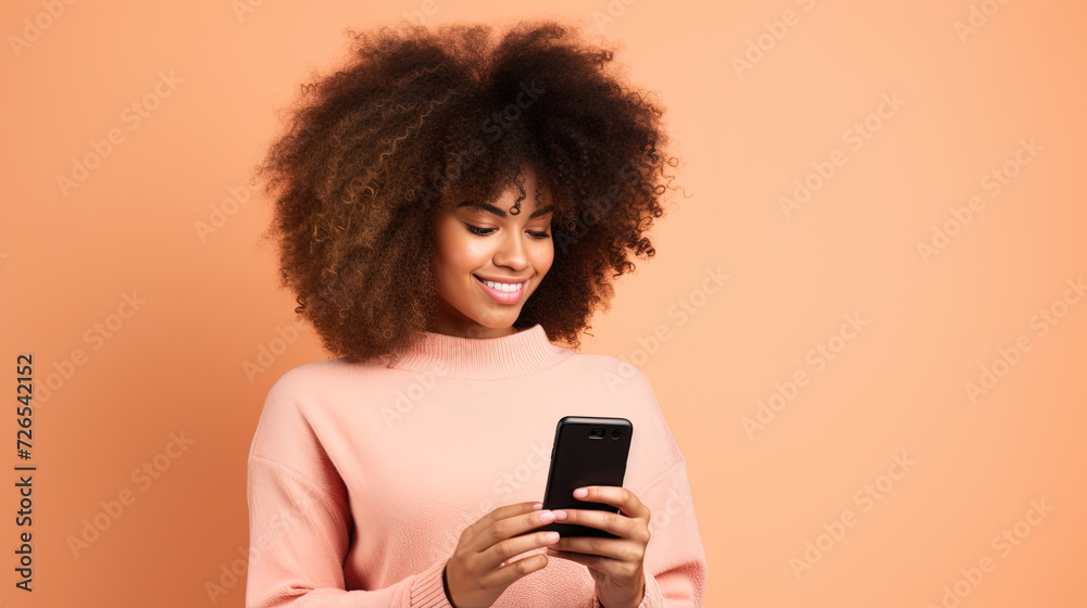Beautiful Black woman with afro hair holding a phone, isolated on a pink background Beautiful Black woman with afro hair holding a phone, isolated on a pink background