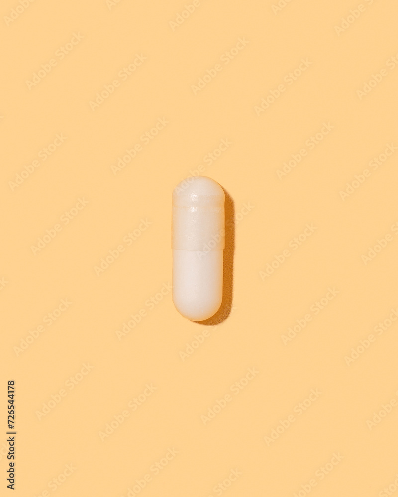 Top view of vitamin pill on yellow colorful background with shadow Top view of vitamin pill on yellow colorful background with shadow