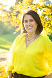 portrait of adult woman with perfect smile at sunset in a park dressed in yellow