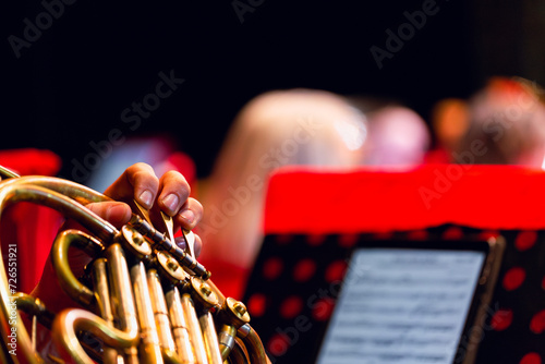 Musicians fingers on brass instrument at concert photo