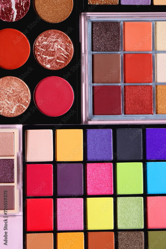 Fototapeta premium Various colorful eyeshadow palettes on bright pink background. Flat lay.