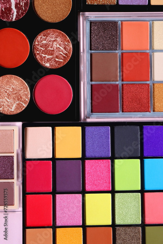 Various colorful eyeshadow palettes on bright pink background. Flat lay.