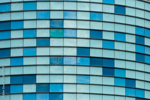 Pattern of windows of office buildings illuminated in the morning. Glass architecture; corporate building - business concept. 