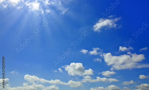 Blue sky background with sunlight and white clouds. Nature summer background.
