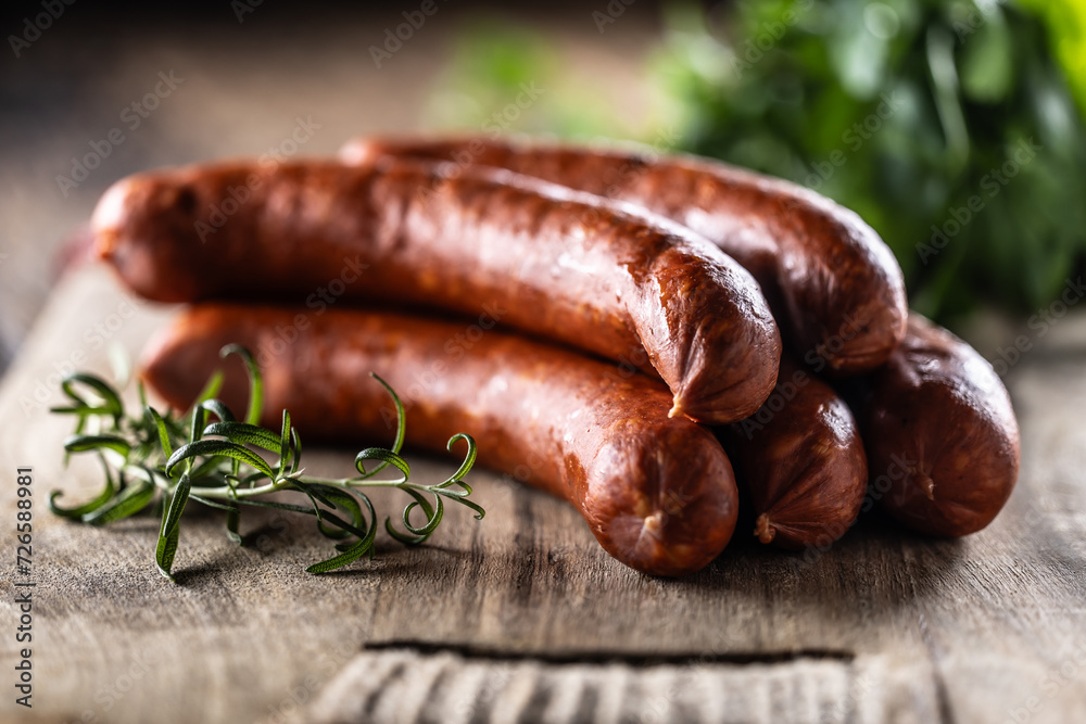 Pepper pork smoked sausages with rosemary on a cutting board Pepper pork smoked sausages with rosemary on a cutting board