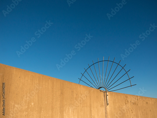 Circular spiked barrier to stop access to dam wall photo