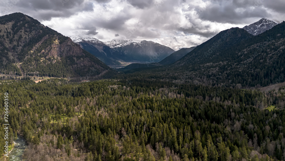 Beautiful mountain landscape. Clouds in the sky. Green grass. Snow on mountain peaks. Beautiful mountain landscape. Clouds in the sky. Green grass. Snow on mountain peaks.
