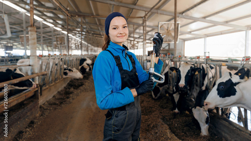 Portrait young woman veterinarian holding syringe with vaccine for holstein cows on background of livestock farm, health care of cattle