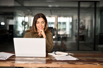 Happy busy mature business woman entrepreneur in office using laptop at work, smiling professional middle aged female company executive manager working looking at computer at workplace.