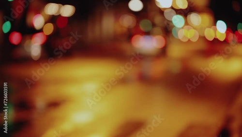 Wet city street with traffic lights refections at night in Paris