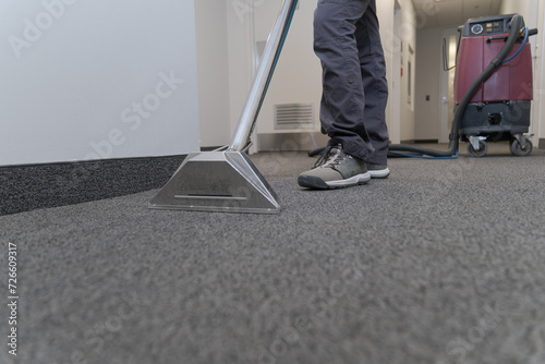 unrecognizable worker cleaning a carpet with a industrial machine