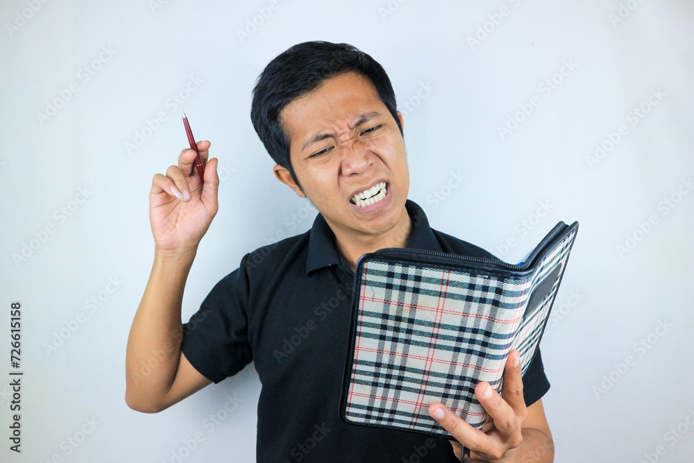 dizzy facial expression of asian man holding pen and notebook, isolated on white background dizzy facial expression of asian man holding pen and notebook, isolated on white background