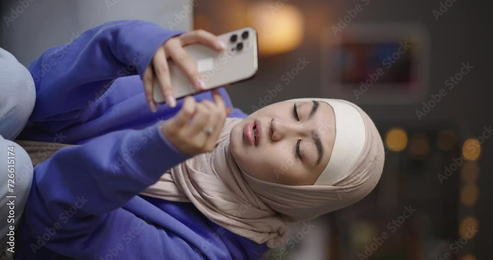 Woman using phone scrolling through. Female blogger scrolls through comments under videos photos rejoices laughs smiles receives positive feedback on content. Teen muslim blogger using social media Woman using phone scrolling through. Female blogger scrolls through comments under videos photos rejoices laughs smiles receives positive feedback on content. Teen muslim blogger using social media