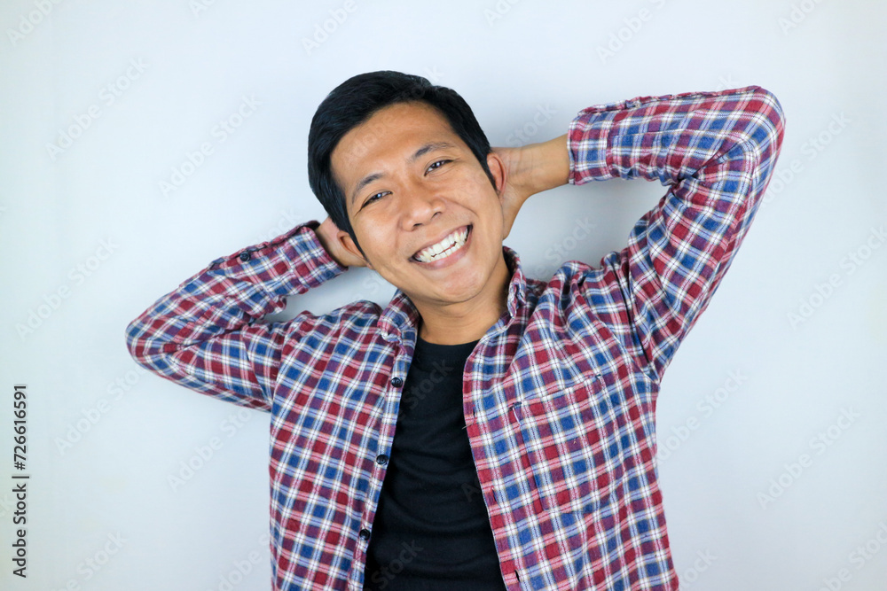 Smiling asian man with arm behind head relaxing peacefully in free time isolated on white background Smiling asian man with arm behind head relaxing peacefully in free time isolated on white background