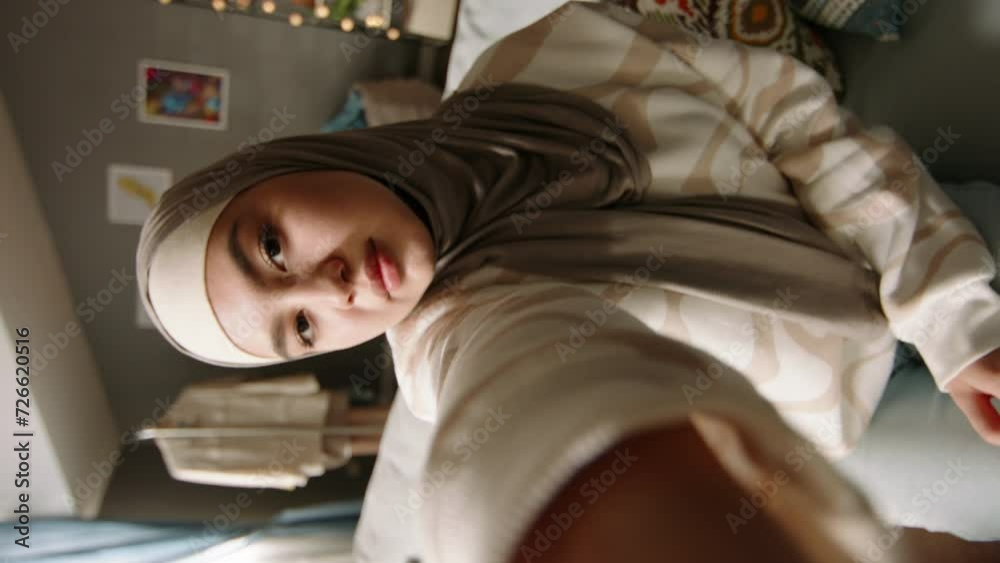 Female muslim blogger smiling making video. Young woman of Generation Z takes photos, smiles laughs experiences happy, incredibly positive optimistic emotions. Muslim blogger posing on video and photo