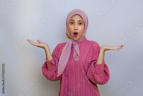 Cheerful muslim woman happy presenting and pointing. using hand to presenting something concept photo