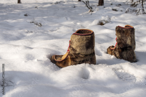 Scandinavian winter sami boots in the snow on a sunny day © Damian Pawlos