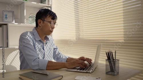 Man using laptop to work on table in office, Press the keyboard on the laptop, Remote work.