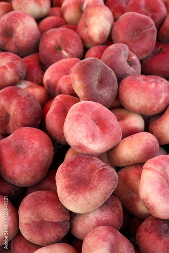 fig peach crop. lots of flat oval peaches at the local market as a background or food texture. © Andrii