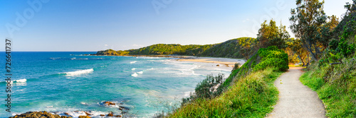 Australian coast with blue water and hills on the ocean shore, view from coastal walk of the sea landscape on a summer sunny day.