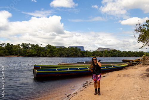 happy smiling woman posing with Curiaras indigenous canoes in Canaima National Park, Venezuela photo