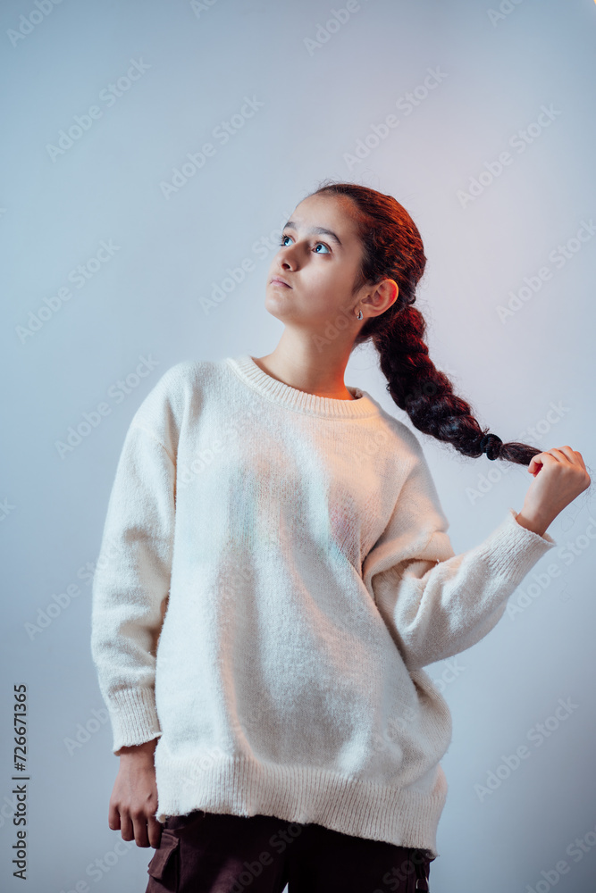 Closeup shot of fashionable girl posing in studio and holding hair
