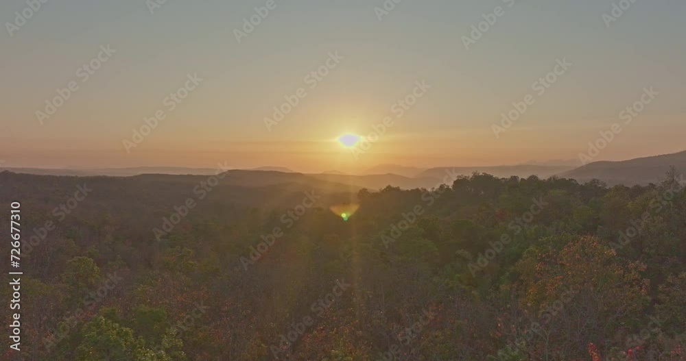 aerial view A beautiful sunrise paints the sky in vivid shades of orange and red over a deciduous forest..Colorful leaves when the season comes to bloom in the big forest..beautiful nature background aerial view A beautiful sunrise paints the sky in vivid shades of orange and red over a deciduous forest..Colorful leaves when the season comes to bloom in the big forest..beautiful nature background