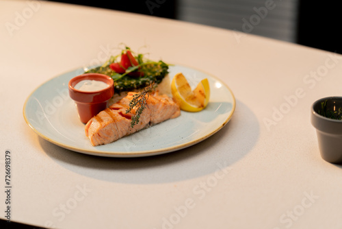 professional cuisine in a hotel restaurant close-up of a delicious dish of battered salmon with boiled rice and spinach