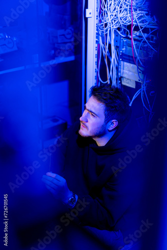 focused hacker in data center hacking software system vulnerable cyber security server room technology digital world metaverse