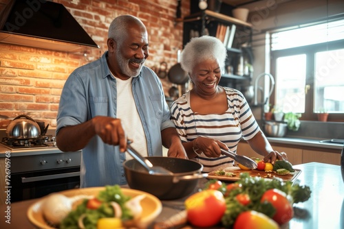 Senior happy smiling african american couple enjoying and cooking healthy dinner together on kitchen at home