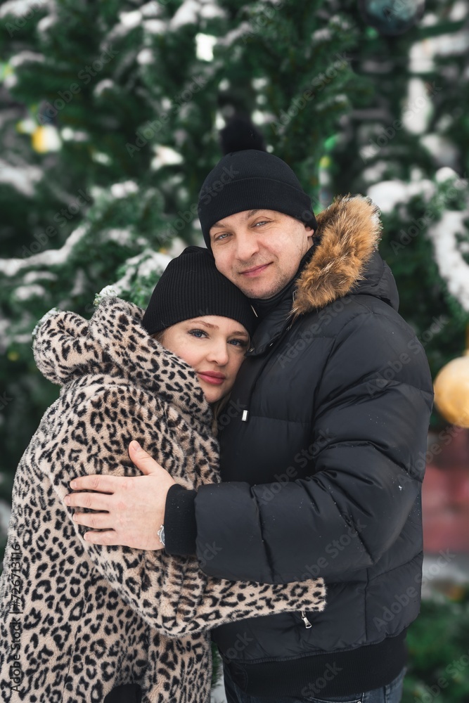Love romantic couple lovestory. Man hugging woman, kissing girl in Christmas winter fur trees decoration. Romantic date. Walking,having fun. Stylish clothes,fur leopard print coat, black jacket, hat Love romantic couple lovestory. Man hugging woman, kissing girl in Christmas winter fur trees decoration. Romantic date. Walking,having fun. Stylish clothes,fur leopard print coat, black jacket, hat