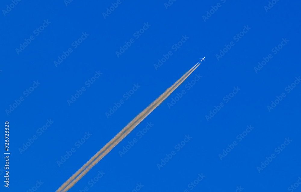 Airplane Flying with Orange Vapor Trails or Chemical Trails Airplane Flying with Orange Vapor Trails or Chemical Trails