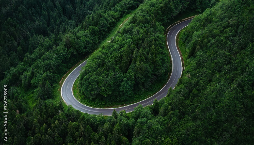 Aerial view of a twisty road in the middle of the forest
