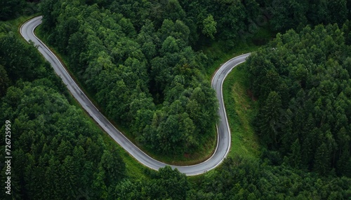 Aerial view of a twisty road in the middle of the forest