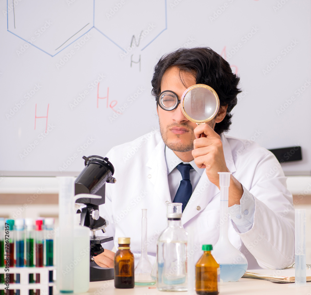 Young funny chemist in front of white board Young funny chemist in front of white board