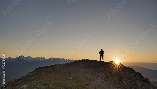 A person standing on the edge of a cliff against a backdrop of mountains and clouds. Concept, freedom, adventure, travelling, mindfulness, meditation or reaching the top. Natural landscape. copy space