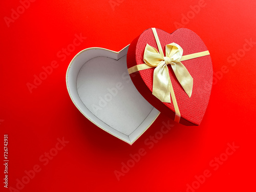 Top view of an open empty heart shaped box on a red background for your products. Happy Valentine's Day, happy women's day, mother's day, birthday.