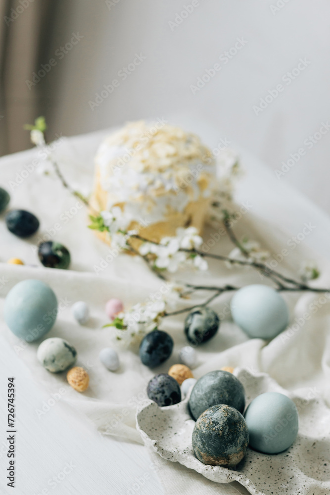 Stylish easter eggs, panettone and spring flowers on linen cloth on rustic table. Natural dye eggs and cherry blossom, festive minimal still life. Happy Easter! Stylish easter eggs, panettone and spring flowers on linen cloth on rustic table. Natural dye eggs and cherry blossom, festive minimal still life. Happy Easter!