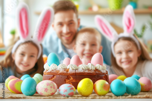 Father and children at festive dinner table with Easter cake and eggs