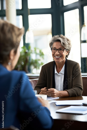 A cheerful businesswoman engaged in a lively discussion with colleagues in a modern office setting.