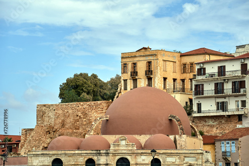 domes of a historic mosque and historic buildings in the port of Chania city on the island of Crete