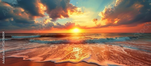 The sun gracefully sets, painting a breathtaking array of warm colors in the sky during a beach sunset.