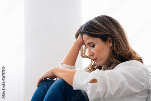 Fotografia Close-up side view of a lonely woman sitting at home with sad look