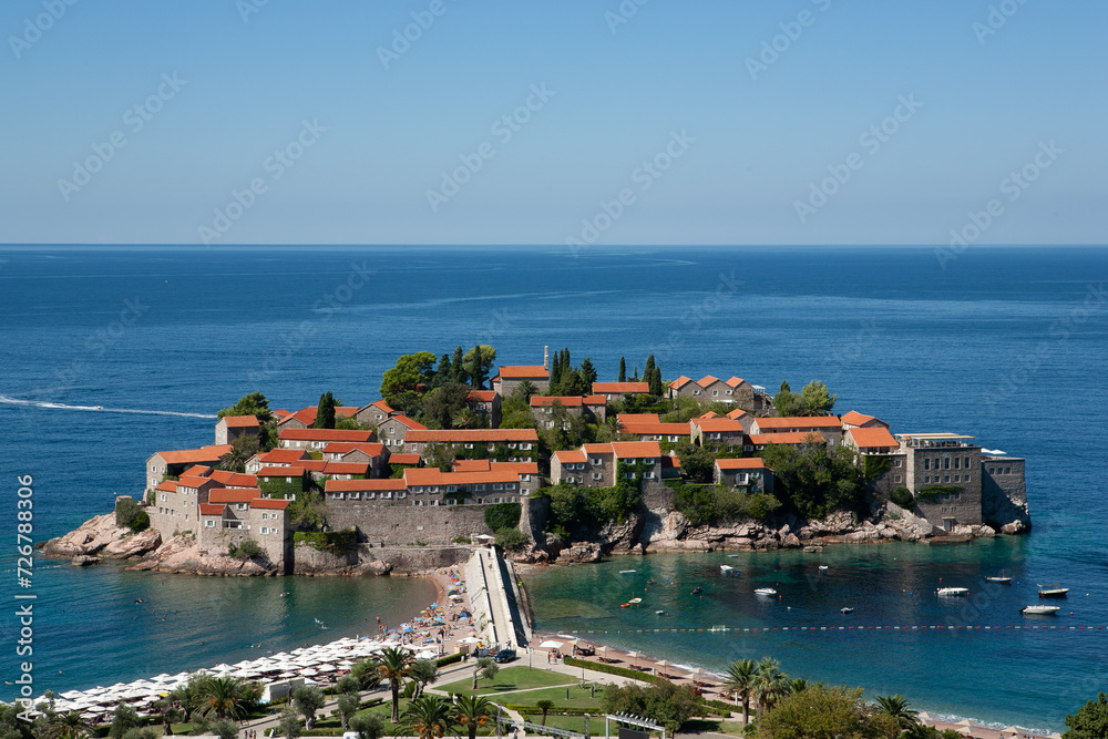View of the island of St. Stephen at sunny day, Montenegro. Aman Sveti Stefan for publication, poster, screensaver, wallpaper, postcard, banner, cover, post. High quality photo View of the island of St. Stephen at sunny day, Montenegro. Aman Sveti Stefan for publication, poster, screensaver, wallpaper, postcard, banner, cover, post. High quality photo