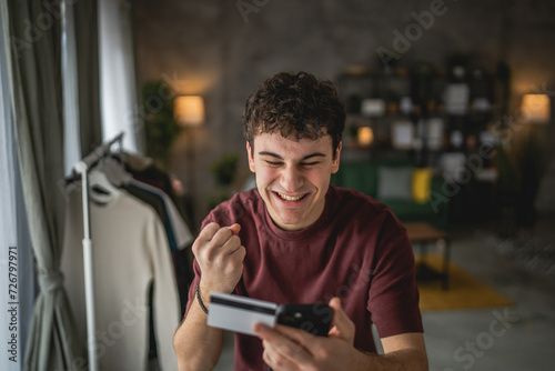 teenager young man sit at home use credit card shopping online