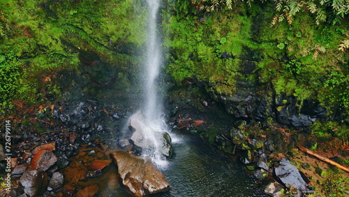 Waterfall jet flowing mossy cliffs aerial view. Streaming water crashing rocks