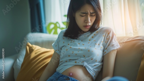 Asian young female suffers from stomachache after eating spoiled food, Abdominal pain from menstrual cramps, Sick woman unhappy having stomach ache digestive problem at home : Generative AI